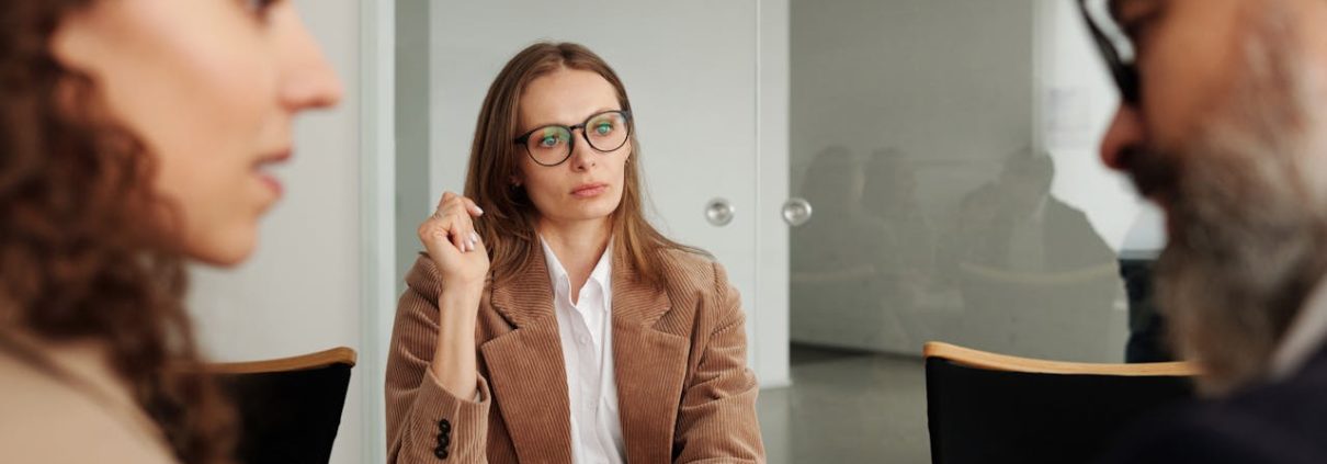 External workplace investigator listens to two employees during an investigation interview meeting