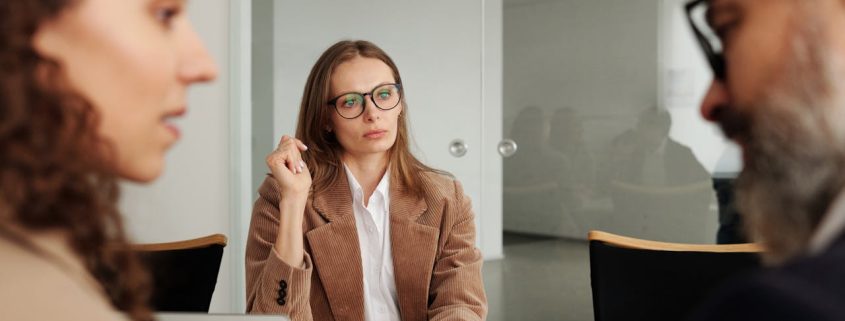 External workplace investigator listens to two employees during an investigation interview meeting